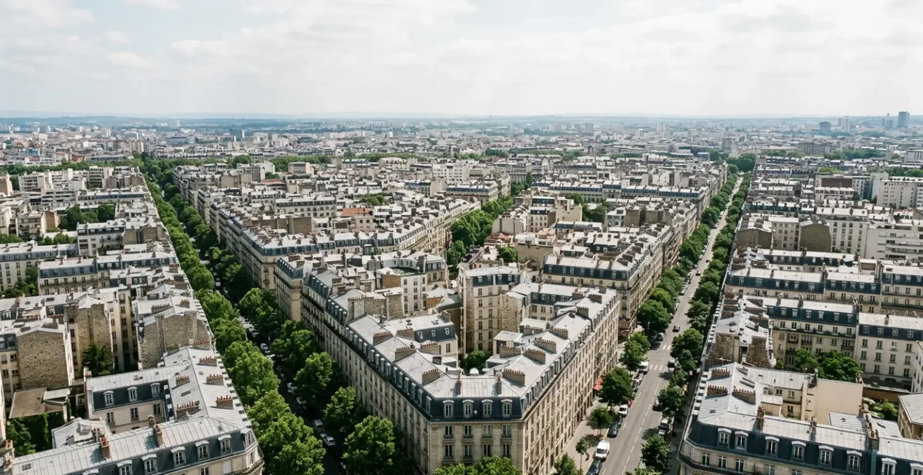 Vue aérienne moderne d'un immeuble haussmannien parisien avec toits en zinc et perspective urbaine dense illustrant la tension immobilière en zone A bis